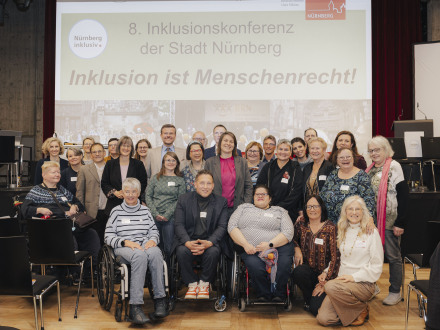 Foto von einer Gruppe von Menschen vor der Bühne bei der 8. Nürnberger Inklusions·konferenz.