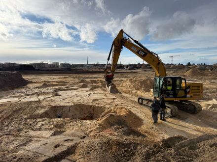 Bild © Berufsfeuerwehr Stadt Nürnberg Foto von den Bau·arbeiten im Stadt·teil Lichtenreuth. Ein Bagger steht neben einem großen Loch im Boden. Neben dem Bagger stehen 2 Personen., Bild © Berufsfeuerwehr Stadt Nürnberg