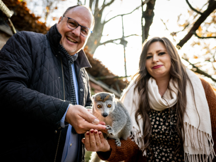Foto von Sonja und dem Bürgermeister Christian Vogel. Sonja hat einen Kronen·maki auf dem Arm.