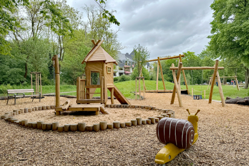 Der neue Spielplatz an der Flußstraße: Kleinkinderbereich mit Baumhaus und Seilbahn.