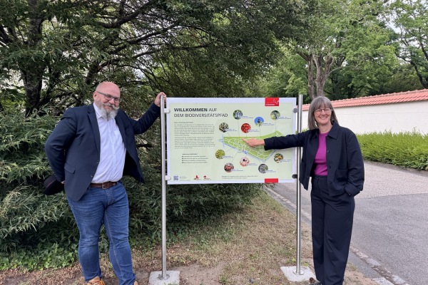 Armin Hoffmann, Leiter der Friedhofsverwaltung, und Britta Walthelm, Referentin für Umwelt und Gesundheit, mit einer der neuen Informationstafeln am Südfriedhof.