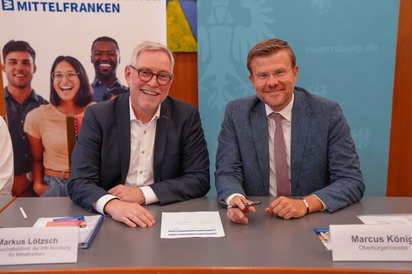 Foto: Der Haupt·geschäfts·führer von der IHK und der Ober·bürgermeister von Nürnberg unterschreiben die Kooperations·vereinbarung für das Work-and-Stay-Center.