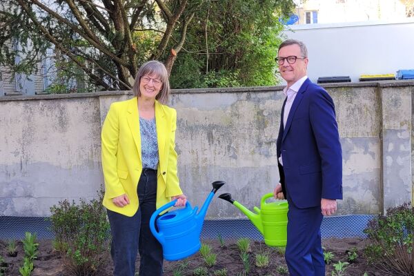 Britta Walthelm, Referentin für Umwelt und Gesundheit und Ralf Schekira, Geschäftsführer der wbg Nürnberg, gießen die gerade gesetzten Pflanzen auf der entsiegelten Fläche in einem Hinterhof in der Rollnerstraße in Nürnberg.