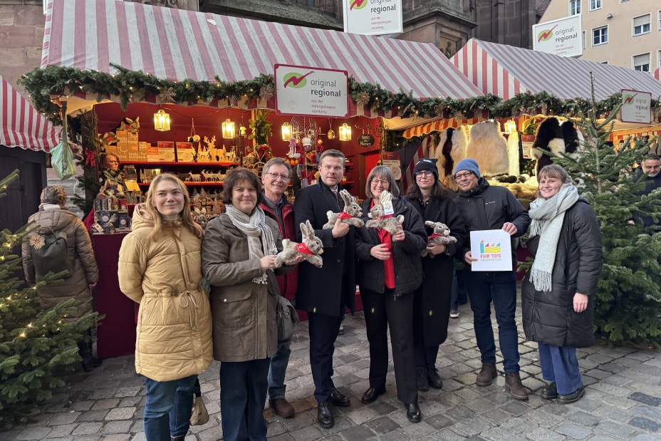 Gemeinsam mit Umweltreferentin Britta Walthelm stellte Oberbürgermeister Marcus König am Donnerstag, 18. Dezember 2025, den fair produzierten Kuschelhasen „Albrecht“ vor. Mit dem Namen knüpft der Hase an den berühmten Dürer-Hasen an und ergänzt künftig das Sortiment der fair gehandelten Stadtprodukte Nürnbergs. Von links nach rechts: Isabell Galster, Bluepingu e. V., Brigitte Hanek-Ures, Fenster zur Welt, Dr. Jürgen Bergmann, Mission Eine Welt, Marcus König, Oberbürgermeister der Stadt Nürnberg, Britta Walthelm, Referentin für Umwelt und Gesundheit, Josephine Dransfeld, Geschäftsführerin Heunec, Steffen Kircher, Fair Toys Organisation, und Laura Nieweg, Fair Toys Organisation.