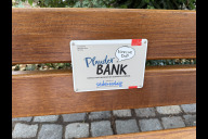 Bild Die erste Plauderbank steht in Nürnberg auf dem Sebalder Platz. Sie wurde am Donnerstag, 17. Juli 2025, der Öffentlichkeit übergeben. Ein Schild weist auf den Zweck hin.