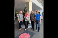 Bild V.l.n.r.: Helmut Blaß, Technischer Werkleiter von NürnbergBad (NüBad), Bürgermeister und Erster Werkleiter von NüBad, Christian Vogel, Saskia Bartelmann, die 100 000. Sauna-Besucherin 2025, und Matthias Bach, Kaufmännischer Werkleiter, im Foyer des Langwasserbads.