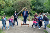 Bild Tag der Demokratie auf dem Erfahrungsfeld zur Entfaltung der Sinne; v.li.: Stefan Schindler, Vorstandsvorsitzender der Sparda-Bank Nürnberg, Oberbürgermeister Marcus König, Jana Stadlbauer, Leiterin der Abteilung kulturelle und politische Bildung des Amts für Kultur und Freizeit, Schülerinnen und Schüler sowie Pädagoginnen des Zentralhorts Welserstraße machen am Montag, 15. September 2025, gemeinsam eine Übung zum Thema Repräsentative Demokratie im Rahmen des pädagogischen Programms. 