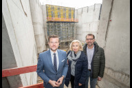 Bild Der Oberbürgermeister der Stadt Nürnberg, Marcus König, Bürgermeisterin Prof. Dr. Julia Lehner und Planungs- und Baureferent Daniel F. Ulrich (v. l. n. r.) stehen in der künftigen Regiekabine über dem Zuschauerraum des Ergänzungsbaus im Innenhof der Kongresshalle. Das Gerüst im Hintergrund markiert den Rand der Hauptbühne.