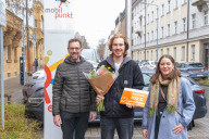 Bild Am heutigen Mittwoch, 26. März 2025, begrüßte Planungs- und Baureferent Daniel F. Ulrich (li.) Nürnbergs 10 000. registrierten Carsharing-Kunden, Daniel Wonner, und überreichte ihm einen Blumenstrauß. Zusätzlich erhielt er von der Carsharing-Betreiberin einen Gutschein über 100 Freikilometer. Überreicht wurde dieser durch Nina Talaj von der Sharegroup GmbH.