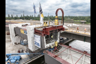 Bild Lückenschluss über dem Main-Donau-Kanal: Am Dienstag, 30. Juni 2026, hat das Projekt Hafenbrücken eine weitere Hürde genommen. Mithilfe zweier Spezialhebegeräte wurde ein 75 Meter langes Brückenteil aus Stahl Zentimeter für Zentimeter in seine Position gebracht.