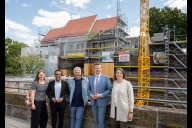 Bild Am Mittwoch, 22. Juli 2026, haben (v. re.) Elisabeth Ries, Referentin für Jugend, Familie, Senioren und Soziales, Oberbürgermeister Marcus König, Hans Rudolf Wöhrl, Stiftungsrat der Emanuel Wöhrl-Stiftung, Bürgermeister Dr. Nasser Ahmed sowie Verena Würth, Pädagogische Leitung des Kinderladens „Die Wilde 15“ e. V., den aktuellen Baufortschritt des neuen Kindergartens auf dem Fürther Tor vorgestellt.