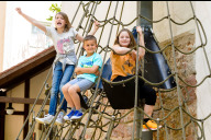 Bild Kinder auf dem Kletternetz des Garten-Spielplatzes im Spielzeugmuseum Nürnberg.