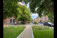 Bild Der umgestaltete Ismail-Yaşar-Platz im Ortsteil Gleishammer ist am Montag, 26. Mai 2025, der Öffentlichkeit übergeben worden. Ein zentraler Weg führt über den Platz und verbindet den Kirchenvorplatz von St. Kunigund mit der Bestelmeyerstraße. Die Eingänge zur Grünanlage sind von Staudenbeeten gesäumt. 