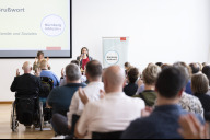 Bild Fachtag Inklusion am Montag, 17. Juni 2024, in der IHK Nürnberg. Das Grußwort von Elisabeth Ries, Referentin für Jugend, Familie und Soziales, und die gesamte Podiumsveranstaltung des ersten Fachtags Inklusion in der Arbeitswelt wurde von Gebärdensprach- und Schriftdolmetscherinnen übersetzt.