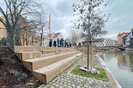 Bild Am Mittwoch, 29. November 2023, wurde der fertiggestellte zweite Bauabschnitt des umgestalteten Nägeleinsplatzes zwischen Weinstadel und Karlstraße der Öffentlichkeit übergeben. Die Sitzstufen laden zum Verweilen am Wasser ein. Der alte Baumbestand wurde bewahrt und durch Neupflanzungen ergänzt.