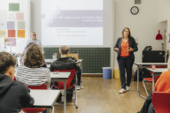 Bild Elisabeth Ries, Jugend- und Sozialreferentin Nürnberg, begrüßt Schülerinnen und Schüler der kaufmännischen Berufsschule 4. Im Hintergrund Workshopleiter Michael Weinhold der Schuldner- und Insolvenzberatung des Instituts für Soziale und Kulturelle Arbeit gGmbH. 