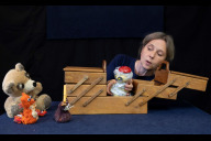Bild Das Bild zeigt die Puppenspielerin Kathrin Blüchert in Aktion bei der Inszenierung von  „Es klopft bei Wanja in der Nacht“. Dabei erwachen verschiedene Tierfiguren in einem Nähkästchen zum Leben.
