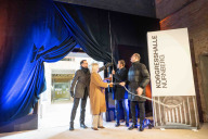 Bild Im Rahmen der Baufeier am Freitag, 23. Januar 2026, wurde die Verbindung zwischen dem denkmalgeschützten Hauptgebäude und dem sogenannten Ergänzungsbau im Innenhof der Kongresshalle symbolisch vollzogen. Planungs- und Baureferent Daniel F. Ulrich, Bürgermeisterin Prof. Dr. Julia Lehner, Oberbürgermeister Marcus König und Staatsminister Albert Füracker haben einen der Übergänge geöffnet, durch die künftig das Publikum von den Foyers im Kongresshallen-Rundbau in den Theaterbau gelangen wird.