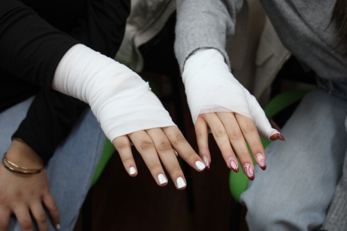 Zwei Schülerinnen präsentieren ihre angelegten Verbände