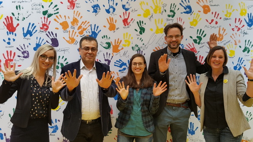 Gruppenfoto der Ausbildungsakquisteur*innen vor einer Wand mit bunten Händeabdrücken