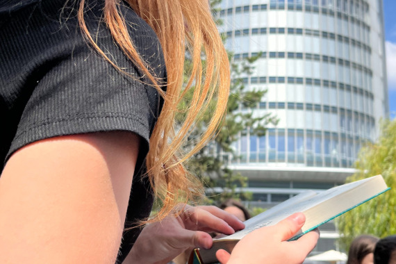 Schülerin liest vor; Business Tower im Hintergrund