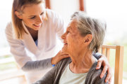 Weibliche Pflegekraft im Gespräch mit alter Frau