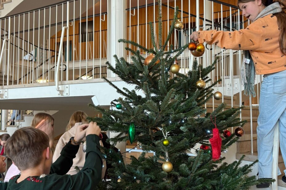Bild © T. Metz / Sigena-Gymnasium Mehrere Schülerinnen und Schüler schmücken den Christbaum in der Aula, Bild © T. Metz / Sigena-Gymnasium