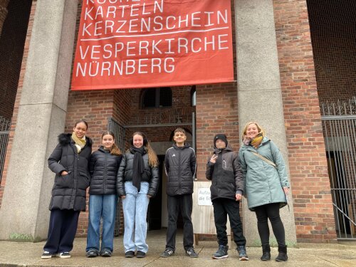 Eine Kindergruppe steht vor einer Kirche