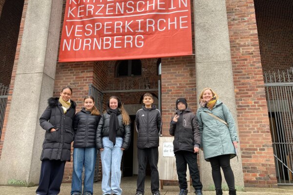 Eine Kindergruppe steht vor einer Kirche