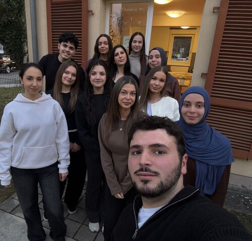 Eine Schülergruppe steht vor dem Eingang zum Schülercafe © I. Aksoy / Sigena-Gymnasium