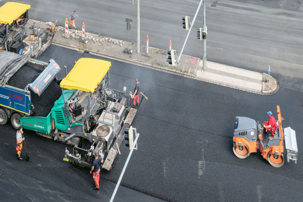Fahrbahndeckensanierung mit Asphaltfertiger und Walze