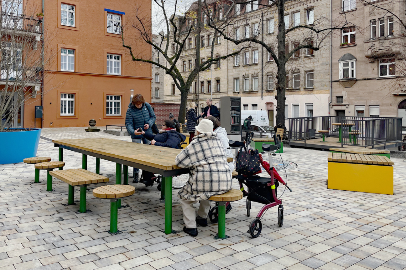 Bei der Gestaltung wurde Wert auf eine inklusionsgerechte Planung gelegt. So gibt es beispielsweise einen Tisch mit Bänken und Hockern, bei denen die Sitzgelegenheiten so angeordnet sind, dass dort auch Rollstühle und Rollatoren Platz finden., Bild © André Winkel / Stadt Nürnberg
