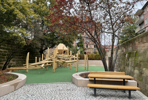 Blick in den neugestalteten Innenhof im Hort Untere Talgasse mit Sitz-Bank-Kombination und Kletter- und Balancierkombination.