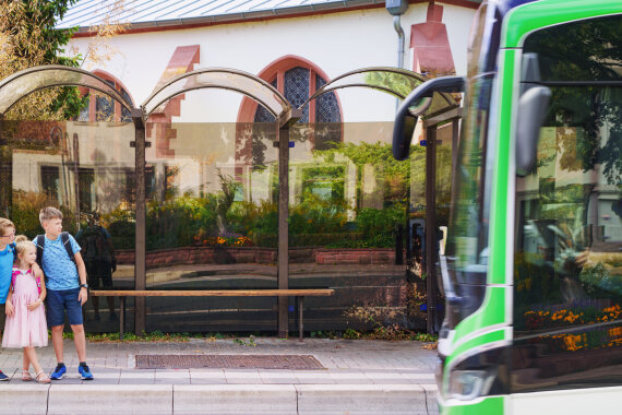 Group of little kids students talking while waiting for school bus at the bus stop