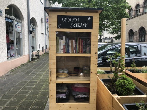 Holzschrank mit Gegenständen zum Tauschen und Verschenken