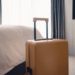 ein Koffer steht neben einem Bett