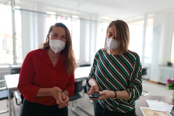 Elina Schnürer und Elisabeth Ries mit Atemschutzmasken im Büro