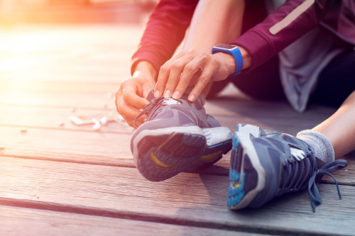 Ein Sportler bindet seine Sportschuhe.