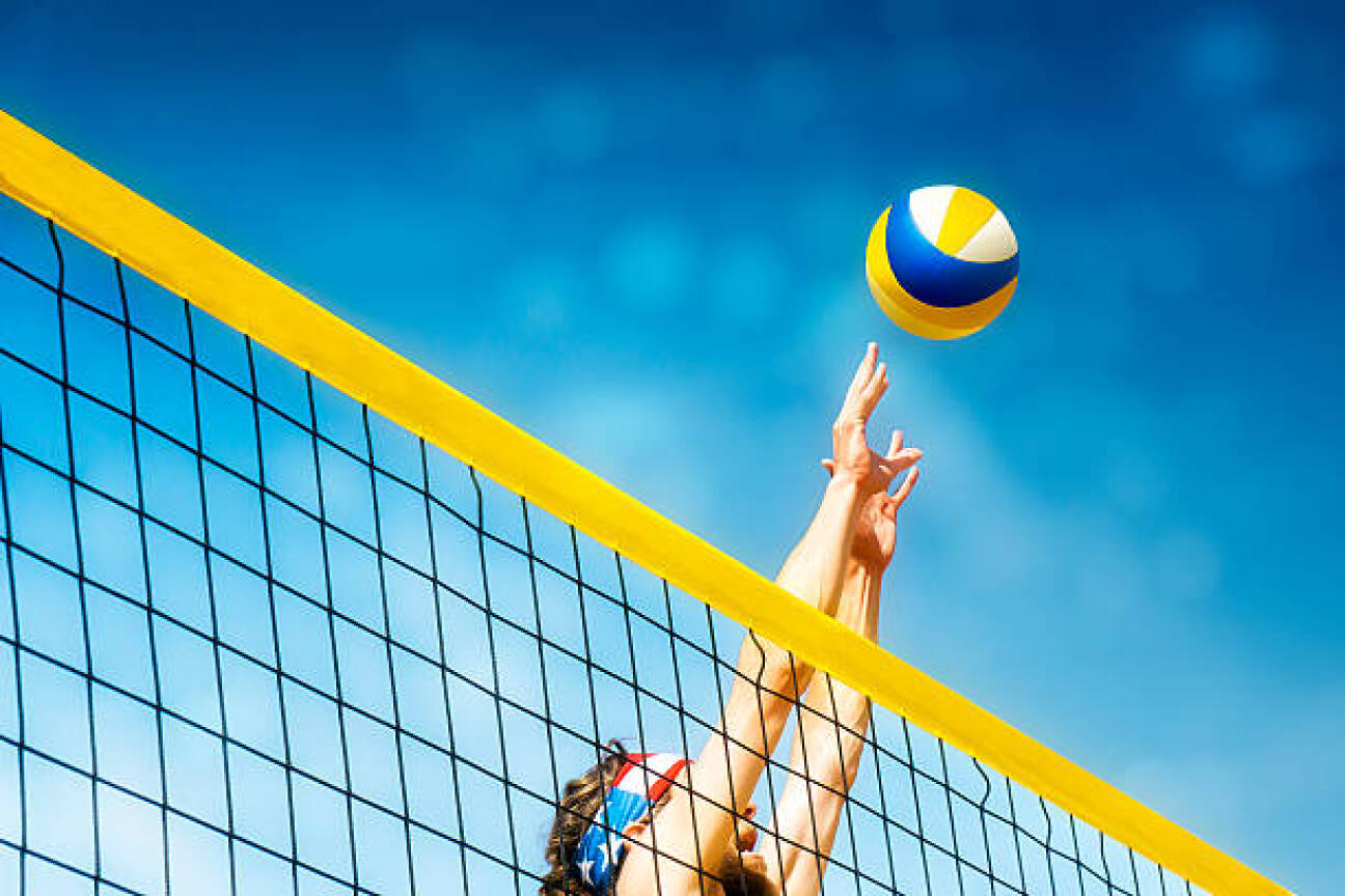 Beachvolley ball player jumps on the net and tries to  blocks the ball, Bild © filrom