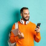 Mann mit Kopfhörer, Smartphone und Tablet