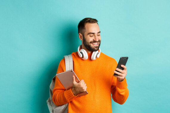 Mann mit Kopfhörer, Smartphone und Tablet