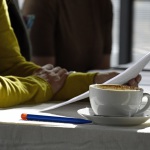 Ein Mensch liest bei einer Tasse Kaffee vor.