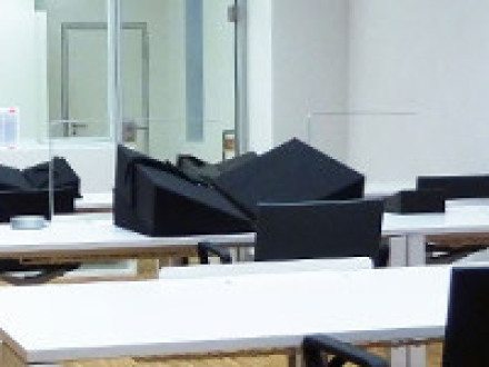 Das Bild zeigt den Lese·saal auf der Ebene L1. In Reihen stehen Tische im Raum. An den Tischen stehen schwarze Stühle.