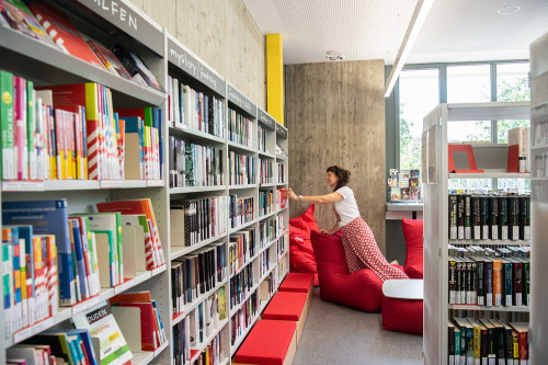 Frau stellt Buch ins Regal © Christine Dierenbach/Amt fuer Kommunikation und Stadtmarketing