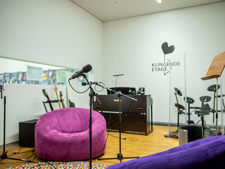 Das Bild zeigt das Klang·studio in der Stadt·bibliothek Zentrum. Es gibt 2 Sessel und verschiedene Instrumente.