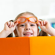 Kind lacht mit orangefarbenen Buch