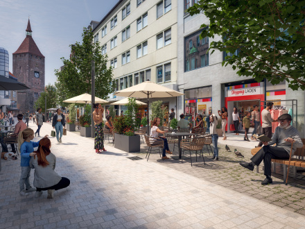 Bild von der Fußgänger∙zone Breite Gasse. Es gibt dort Geschäfte und Cafés. An den Seiten sind Bäume gepflanzt. Viele Menschen halten sich dort auf. Im Hintergrund ist ein Turm zu sehen. Das Bild ist mit einem Computer gemacht.