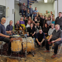 Mitglieder des Borgo Ensembles auf einer Treppe und mit Schlagzeug im Vordergund im Jahr 2023.