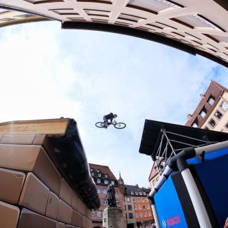 Blick von unten auf Mountainbiker im Flug über den Hauptmarkt.