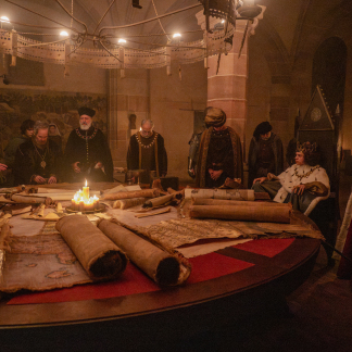 Die Schauspieler Stephen Dillane, Tom Hollander, Stanley Townsend (im Vordergrund v.l.n.r.), Woody Norman (2.v.r.)  und Katherine Waterston (rechts) beraten sich im Pellerhaus.